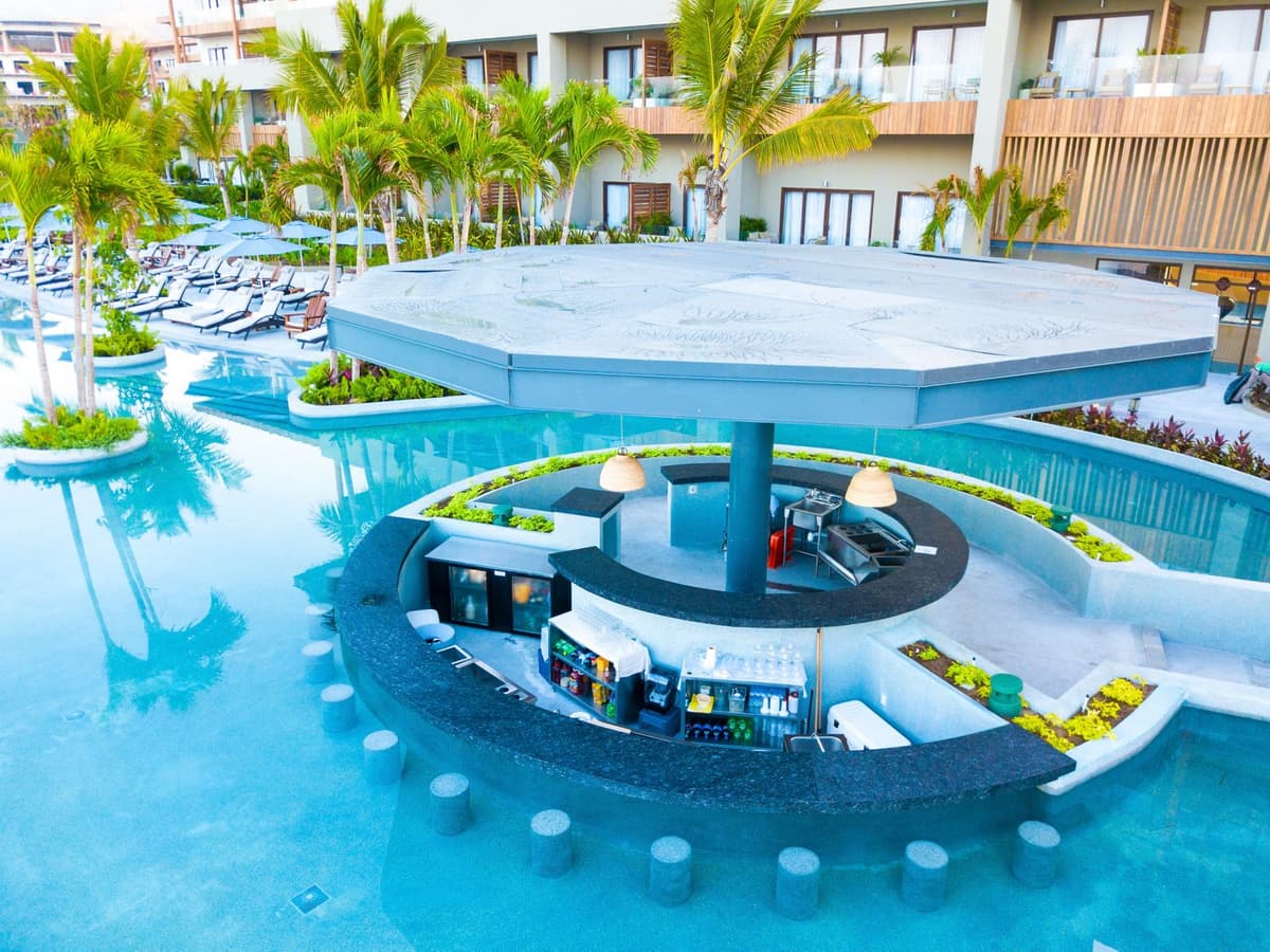 Aerial view of the resort swim-up bar set within a modern pool with ocean views