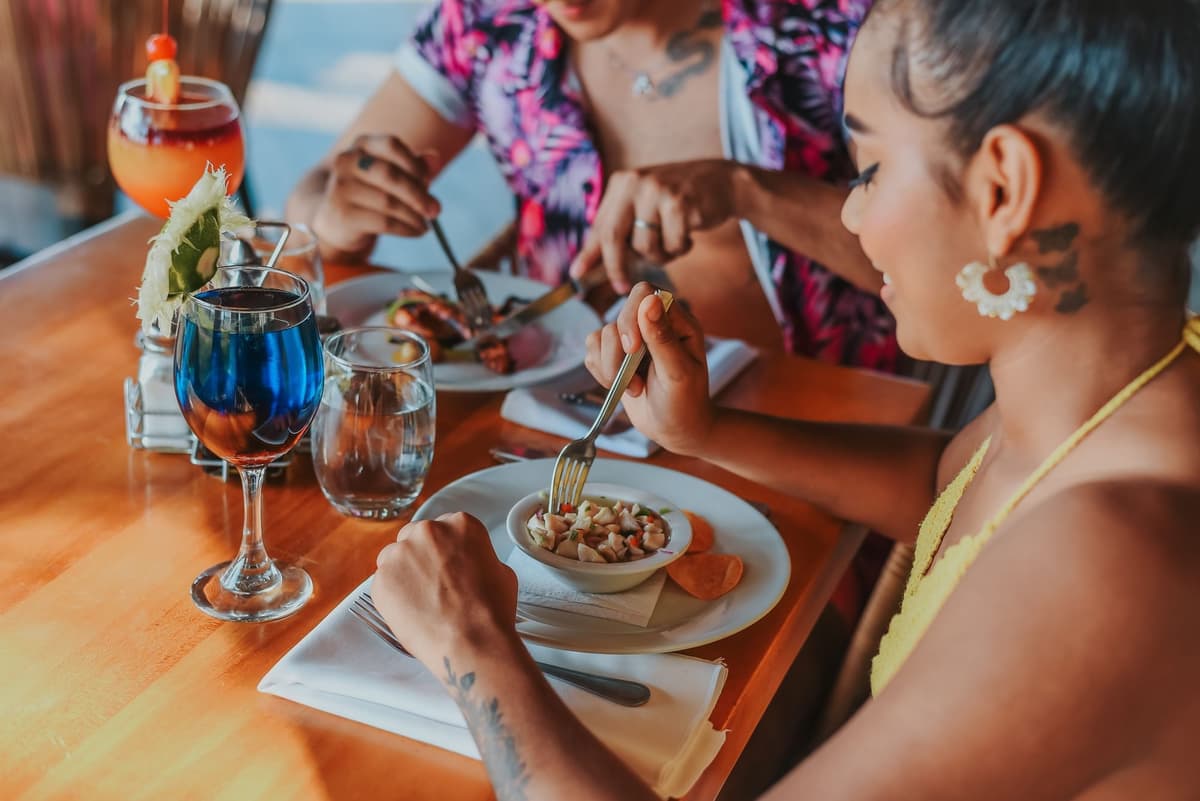 Dark volcanic sand Pacific beach with dramatic sunset views — a signature Fiesta Resort experience
