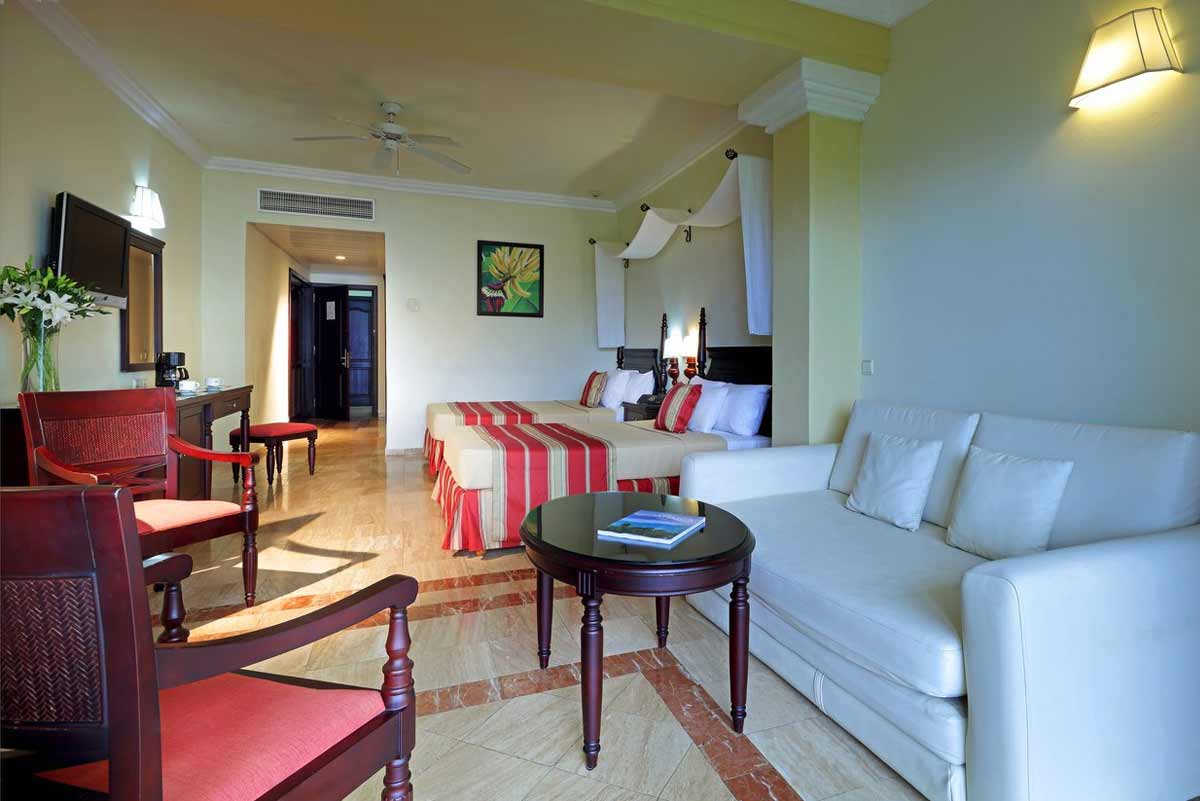 Pool area at Grand Palladium Jamaica Resort featuring built-in jacuzzi sections, lounge chairs, and Caribbean palm trees