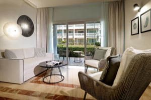 Junior Suite Garden View featuring renovated colonial-style decor, king bed with memory foam mattress, 55-inch TV, and furnished balcony