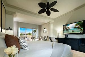 Junior Suite Poolside with combined living area, sofa bed, hydromassage bathtub, and balcony overlooking the pool complex