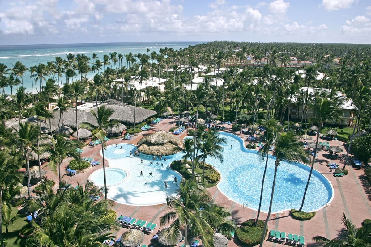Panoramic view of Grand Palladium Palace Resort with low-rise buildings nestled among palm trees along the Dominican Republic coast