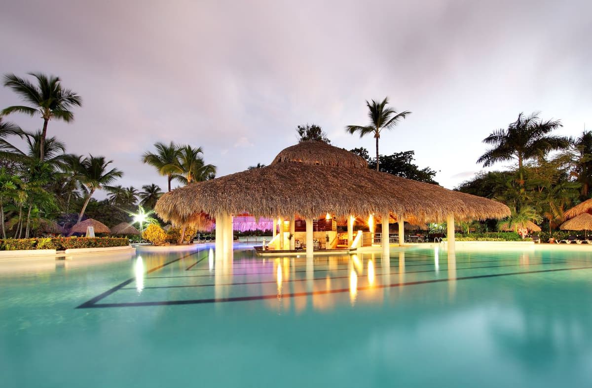 Pool area at Grand Palladium Palace Resort featuring built-in jacuzzi sections, lazy pool areas, and Caribbean palm trees