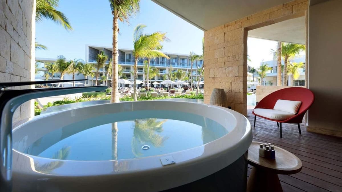 Pristine white-sand Caribbean beach at Costa Mujeres with turquoise waters, loungers, and umbrellas