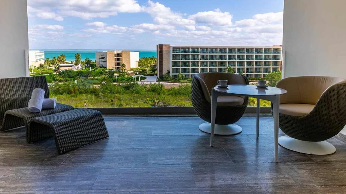 Beachfront view at Grand Palladium Select Costa Mujeres showing wide white sand, crystal-clear Caribbean Sea, and resort facilities