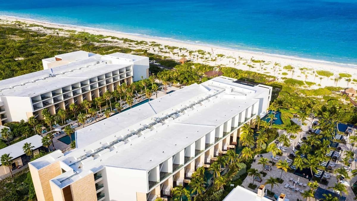 Main swimming pool at Grand Palladium Select Costa Mujeres with loungers, sun shades, and the Splash swim-up bar
