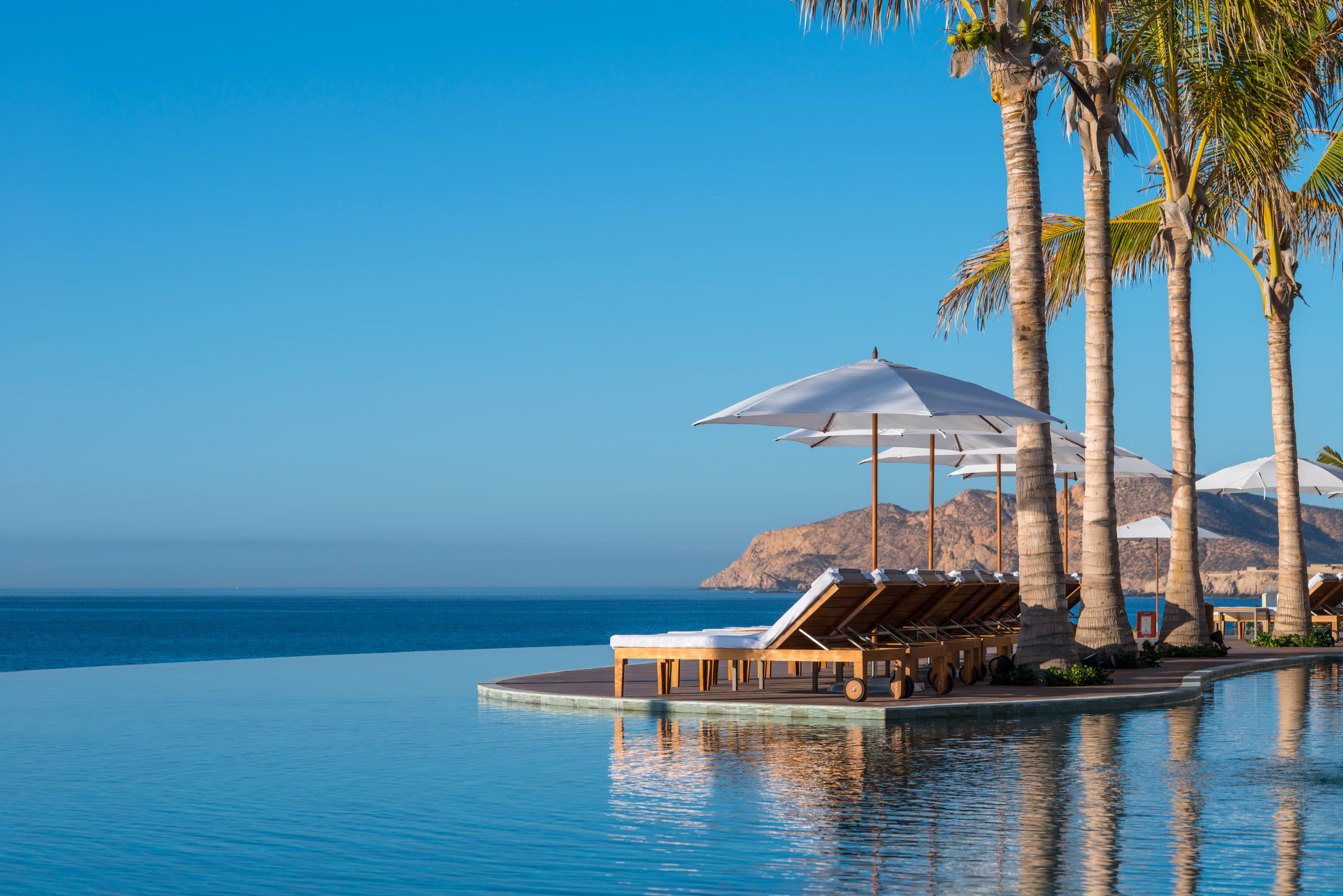 Three-tiered infinity pools cascading toward the Sea of Cortez