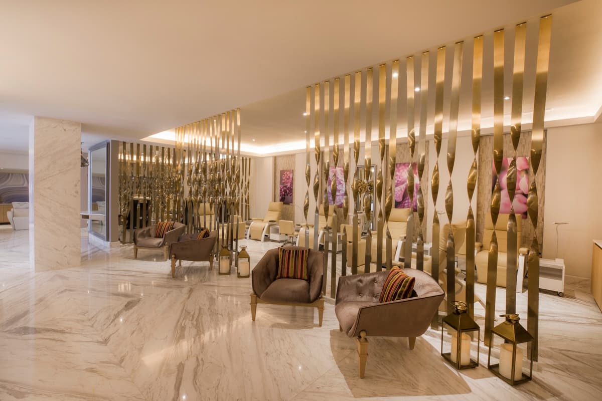 Elegant lobby with gold sculptural partitions, marble floors, and designer furnishings