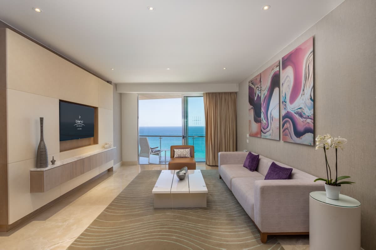 Royale suite living room with ocean-view terrace, modern art, and luxury furnishings