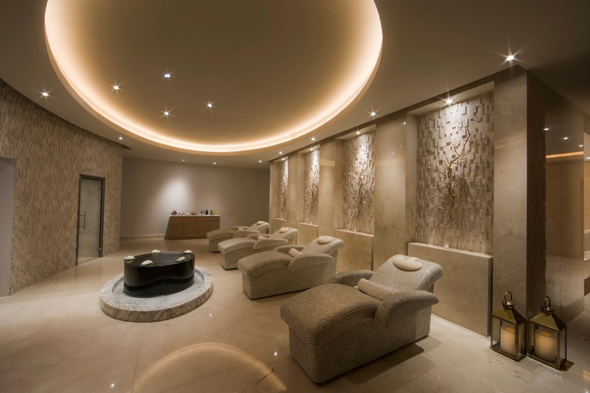 Spa relaxation lounge with sculptural wall features, designer chairs, and warm lighting