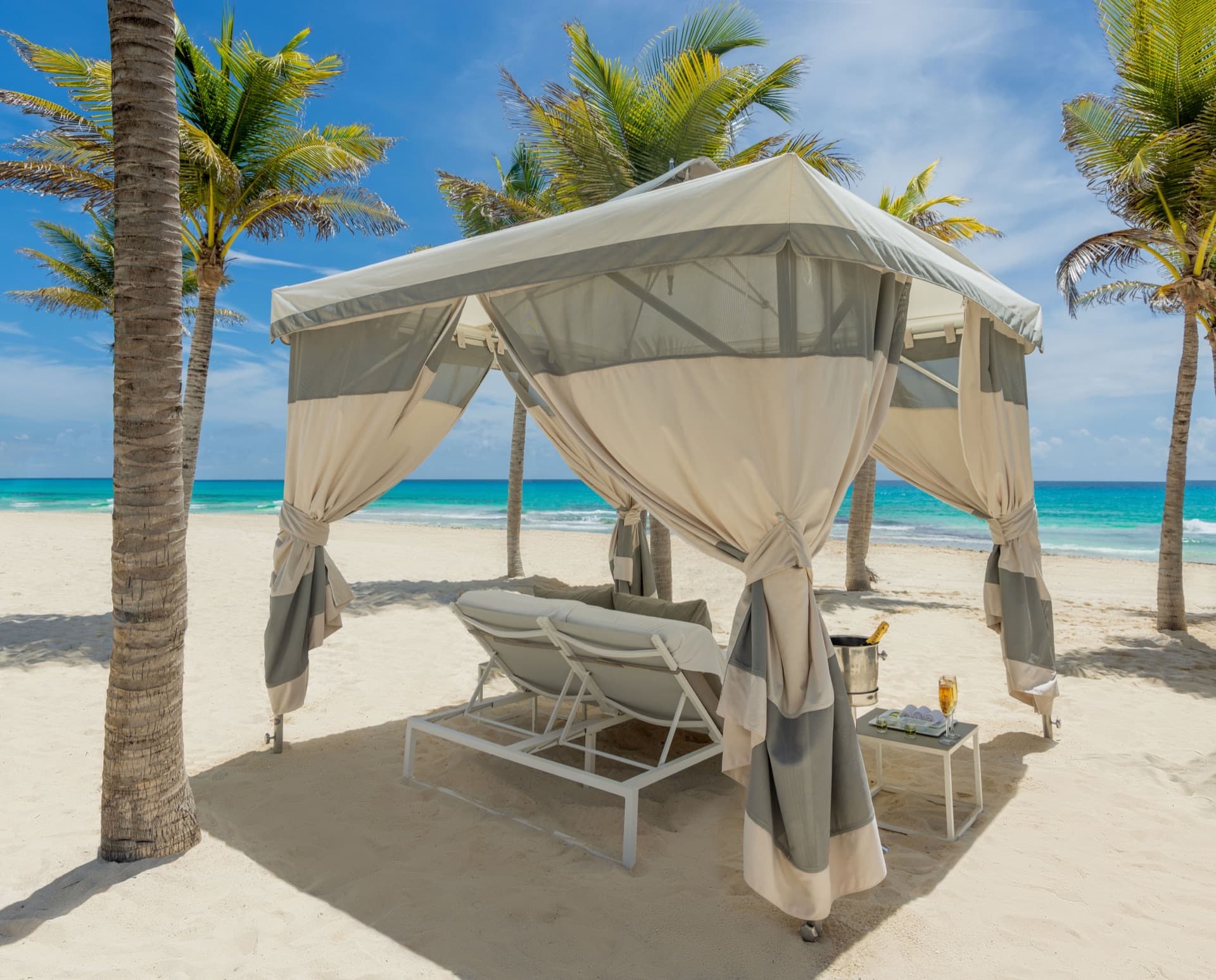 Private beach cabana with palm trees and turquoise Caribbean waters