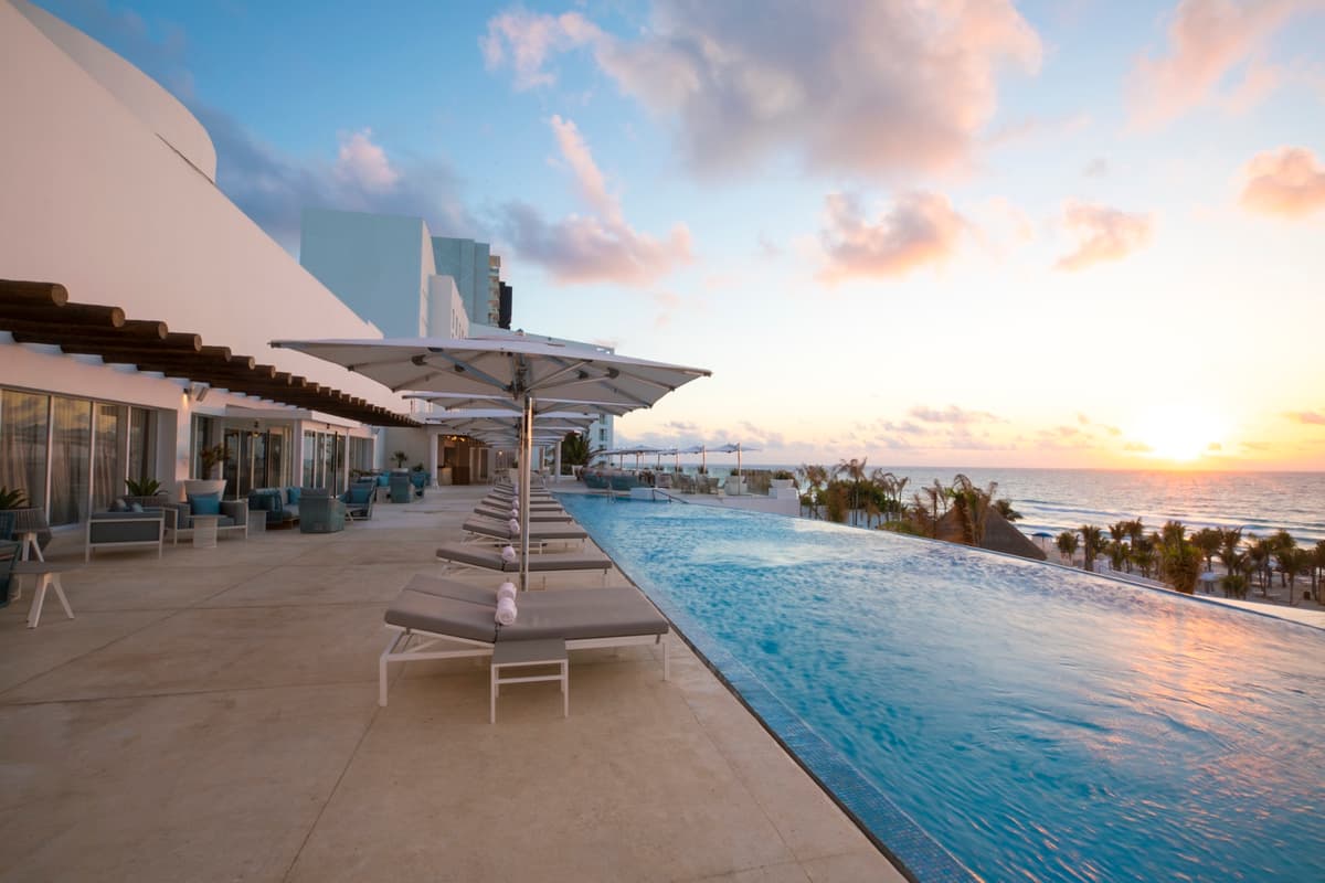 Rooftop infinity pool overlooking the Caribbean Sea at sunset