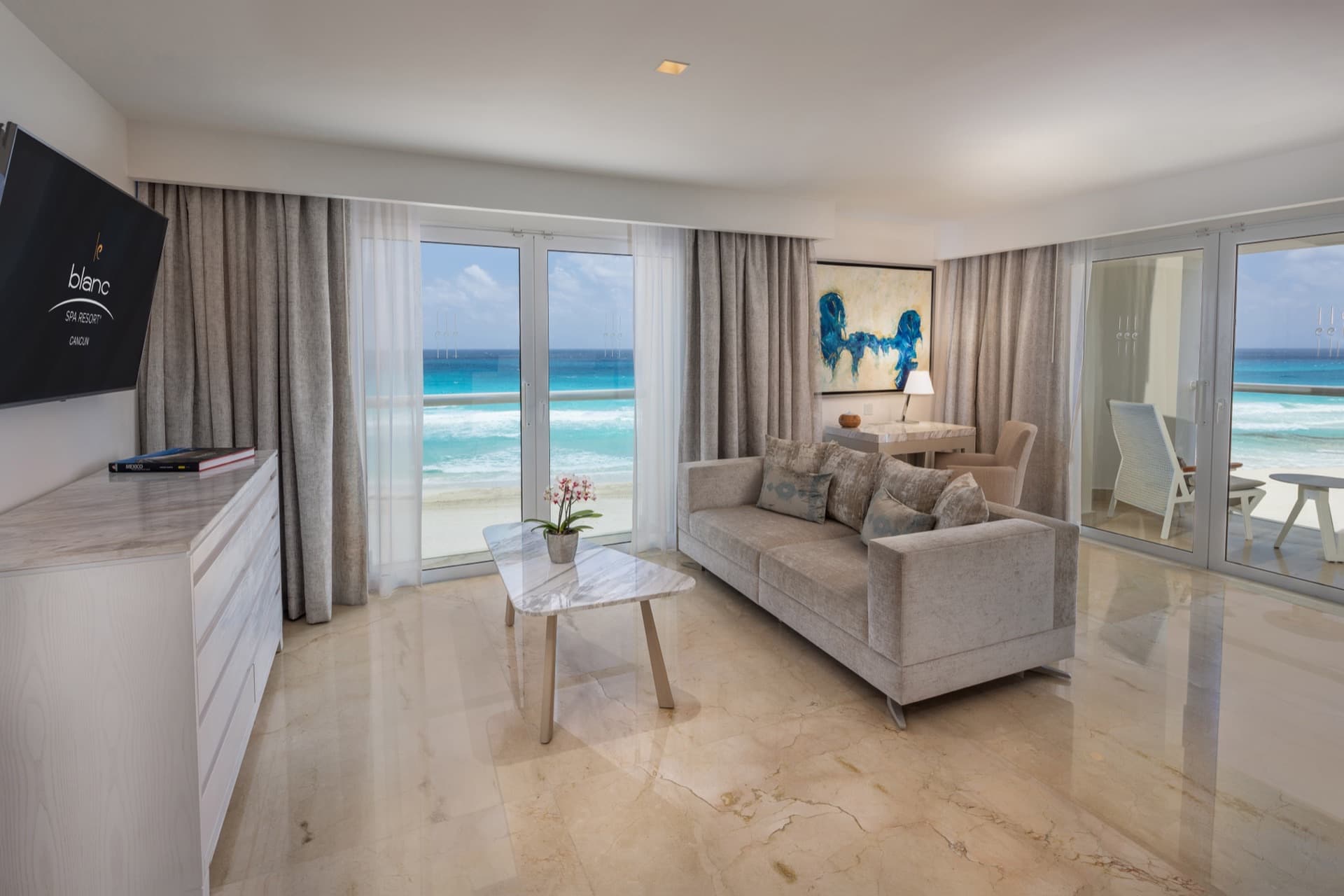 Suite living room with panoramic ocean views through floor-to-ceiling windows