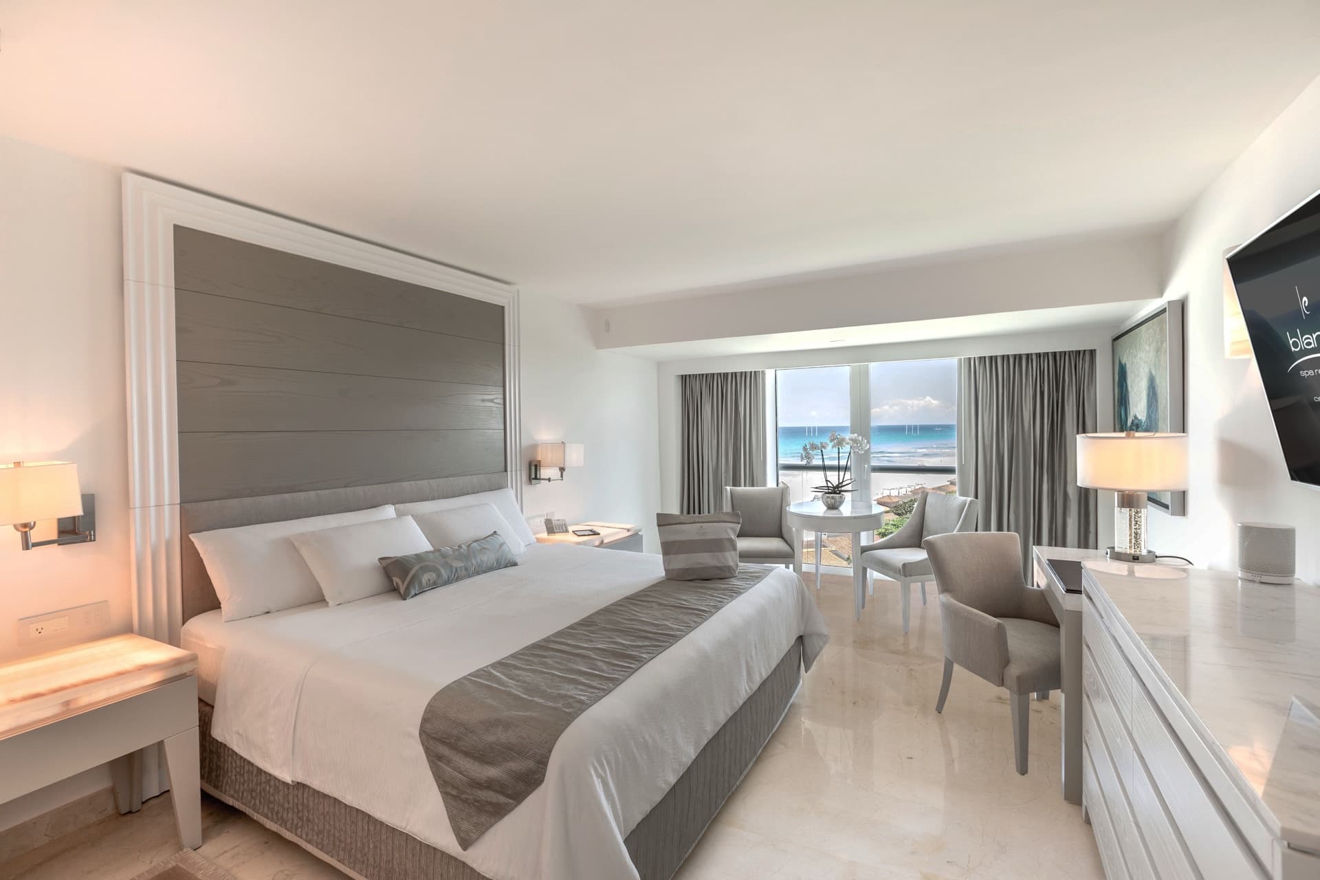 Royale suite bedroom with king bed, ocean view, and contemporary decor