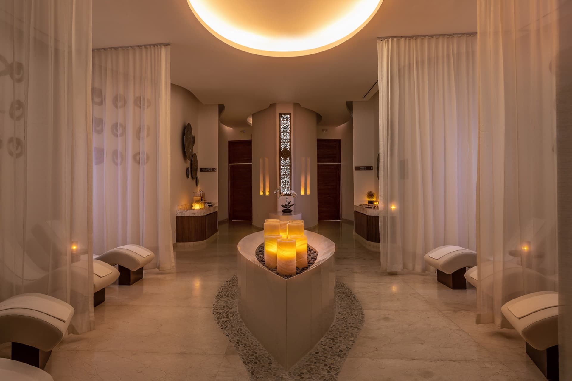 Spa relaxation lounge with candlelit fountain and ethereal curtains