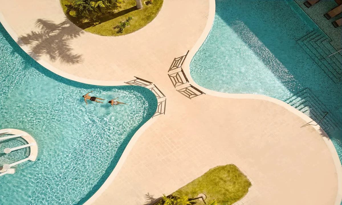 Main TRS Turquesa pool with loungers and tropical surroundings