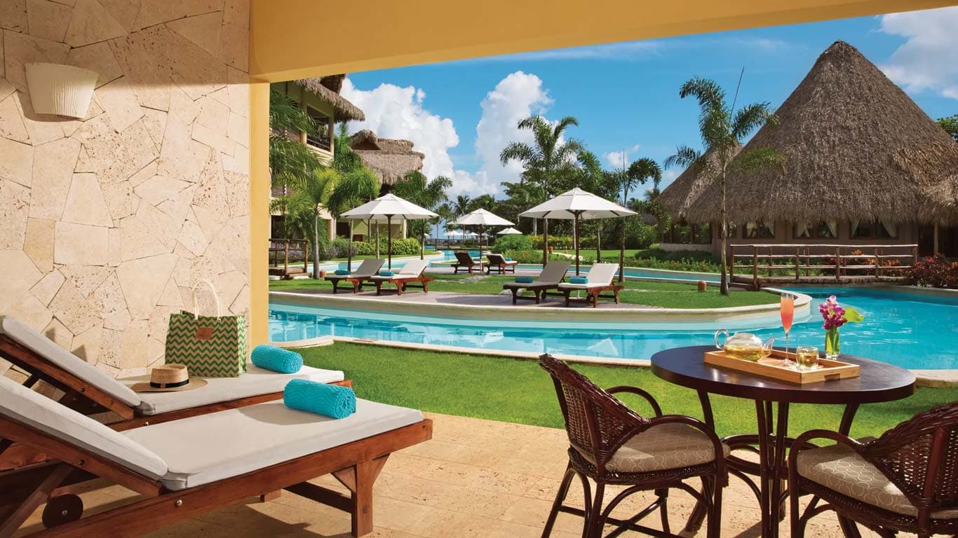 Garden View Agua Junior Suite terrace with direct pool access, loungers, and tropical cocktails