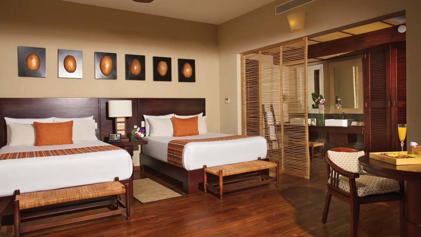 Suite Taino with two queen beds, Dominican artwork, hardwood floors, and bamboo room divider