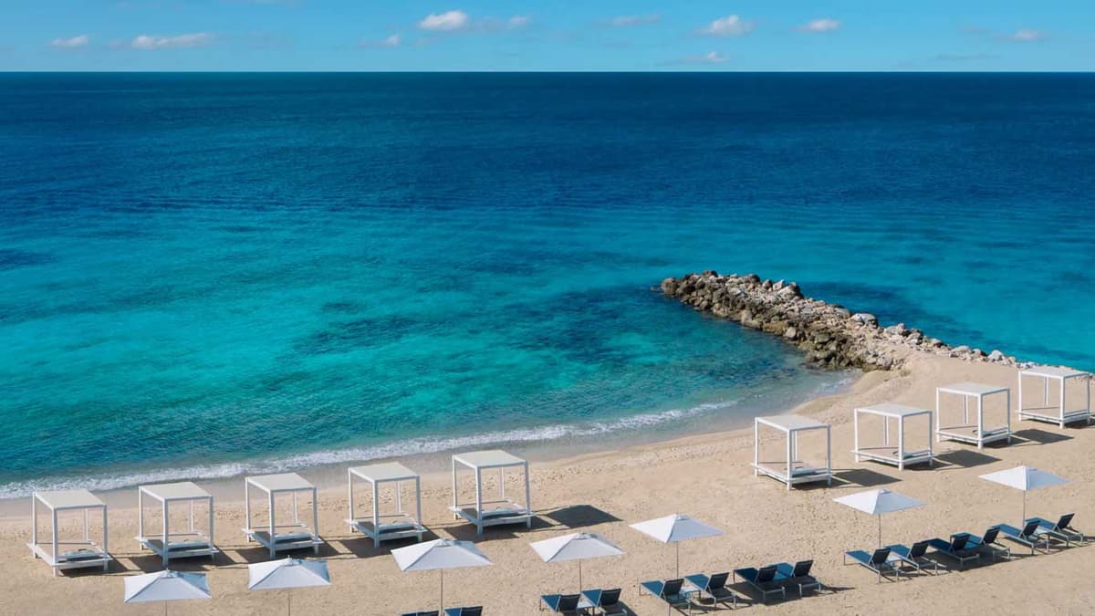 Parasasa Beach with white Bali beds and crystal-clear turquoise Caribbean waters protected by stone breakwater