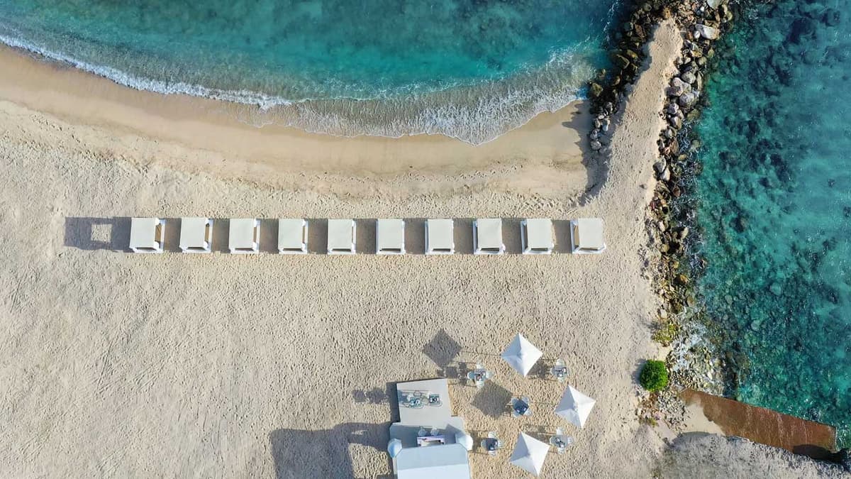 Aerial view of Parasasa Beach showing Bali beds lined along the white sand with turquoise waters