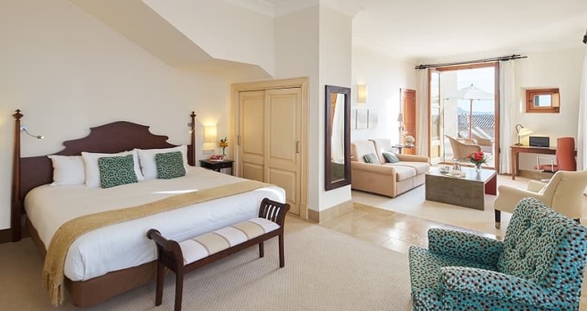 Vaulted stone banquet hall with original Mallorcan mares stonework arches and elegant white-linen dining setup