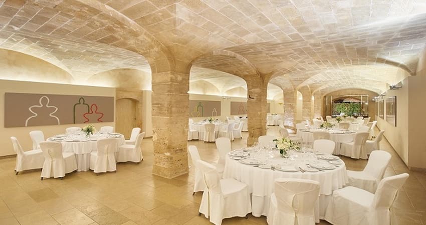 Historic 15th-century stone windmill on the Sa Torre estate grounds with cocktail tables and parasols