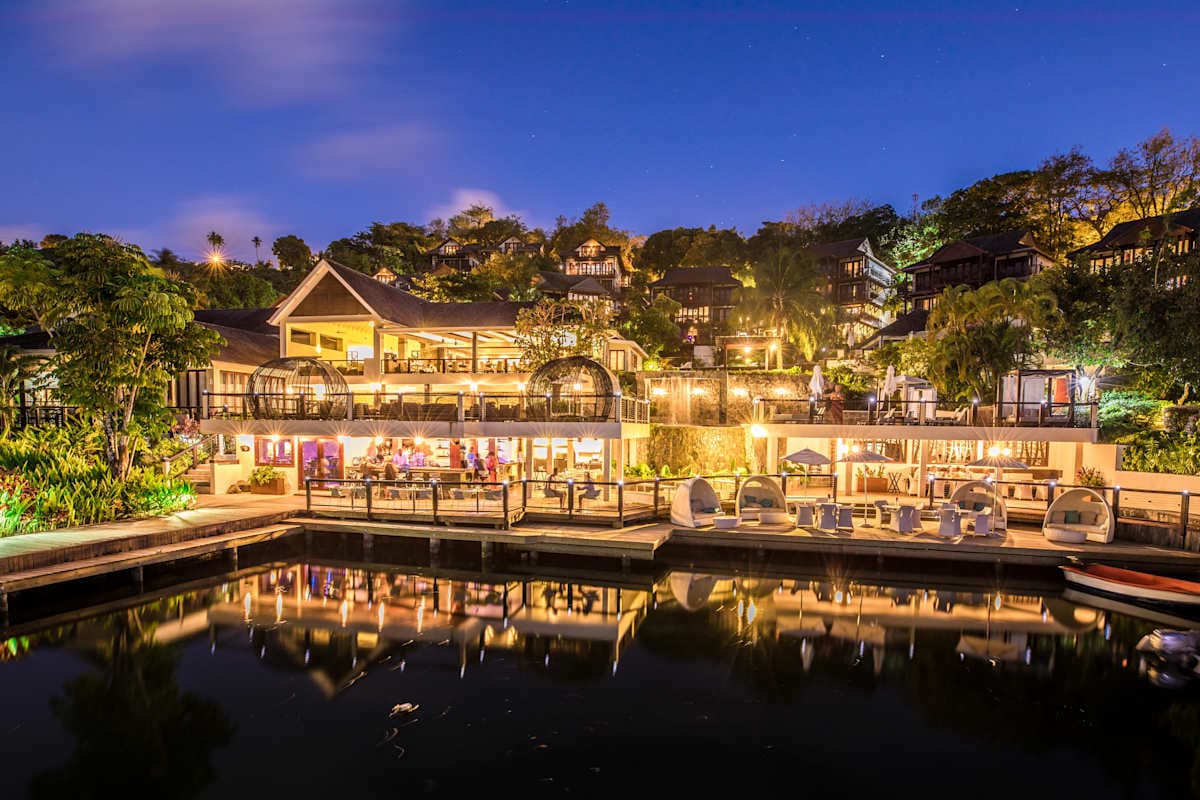 Zoetry Marigot Bay illuminated at night with warm lighting reflecting off the marina waters
