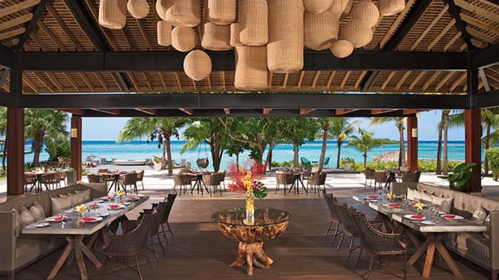 Open-air beachfront restaurant at Zoetry Montego Bay with thatched roof and ocean views