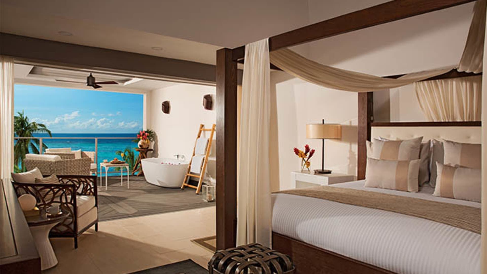 Ocean-view suite at Zoetry Montego Bay with four-poster canopy bed and balcony soaking tub