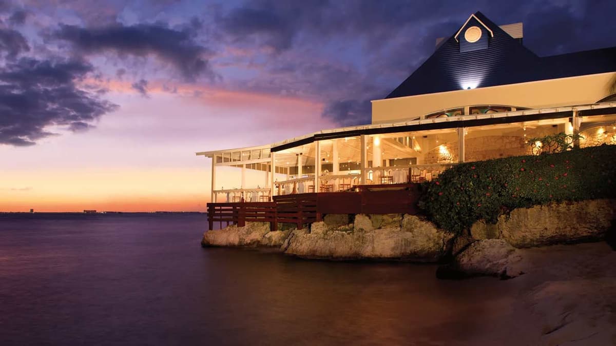 Casa Rolandi restaurant perched over the Caribbean Sea at sunset with its signature blue pyramid roof