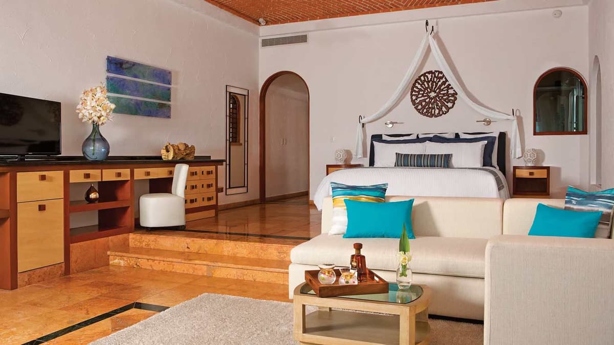 Junior Suite Superior interior with canopied king bed, Tikul stone floors, and seating area