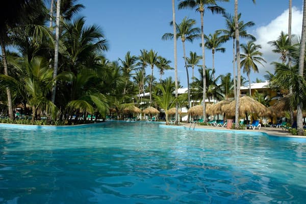 All-inclusive resort experience at Grand Palladium Palace showing the Infinite Indulgence program with dining, pools, and Caribbean lifestyle