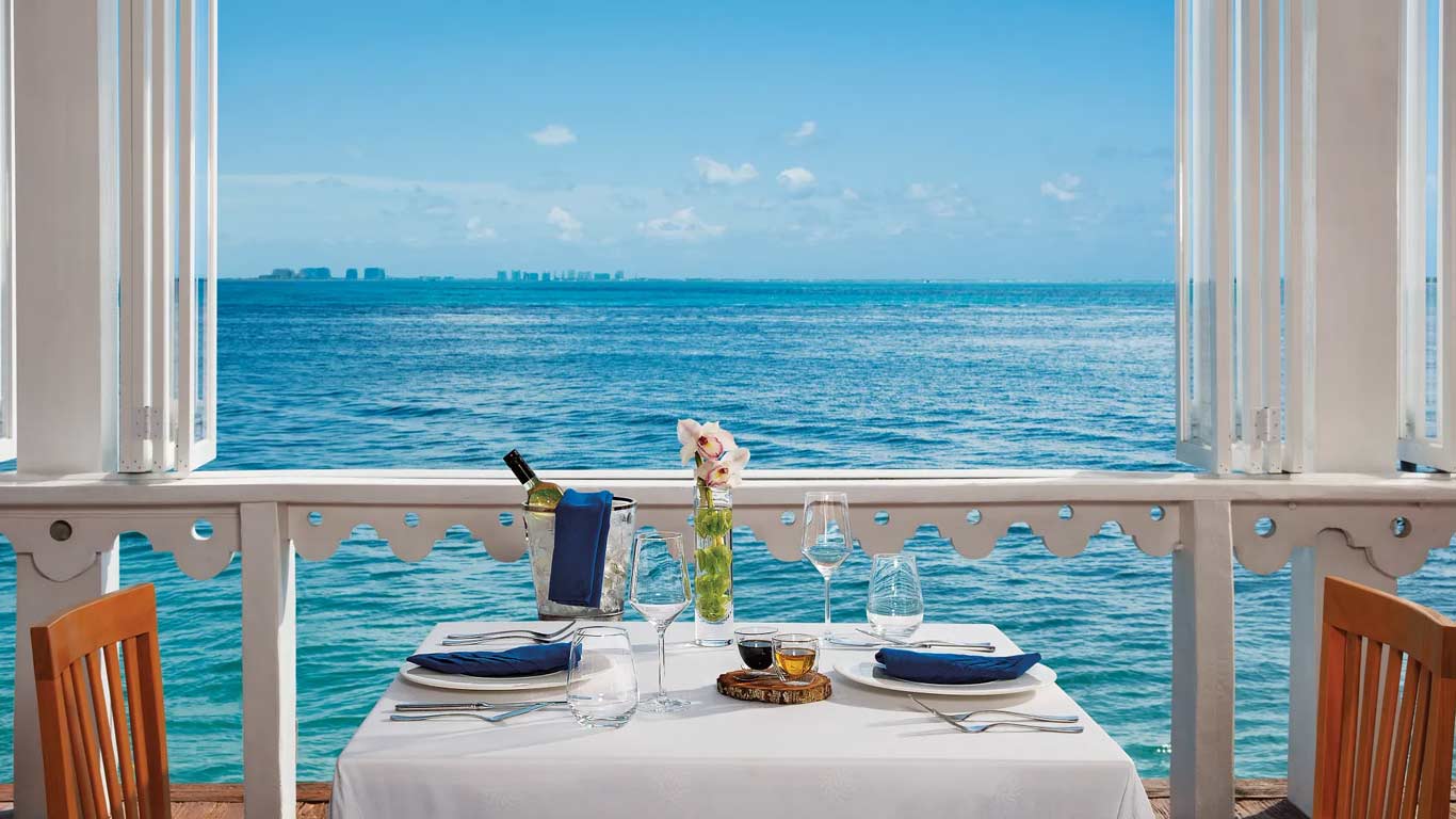 Oceanfront dining table at Casa Rolandi with Caribbean Sea views and Cancun skyline