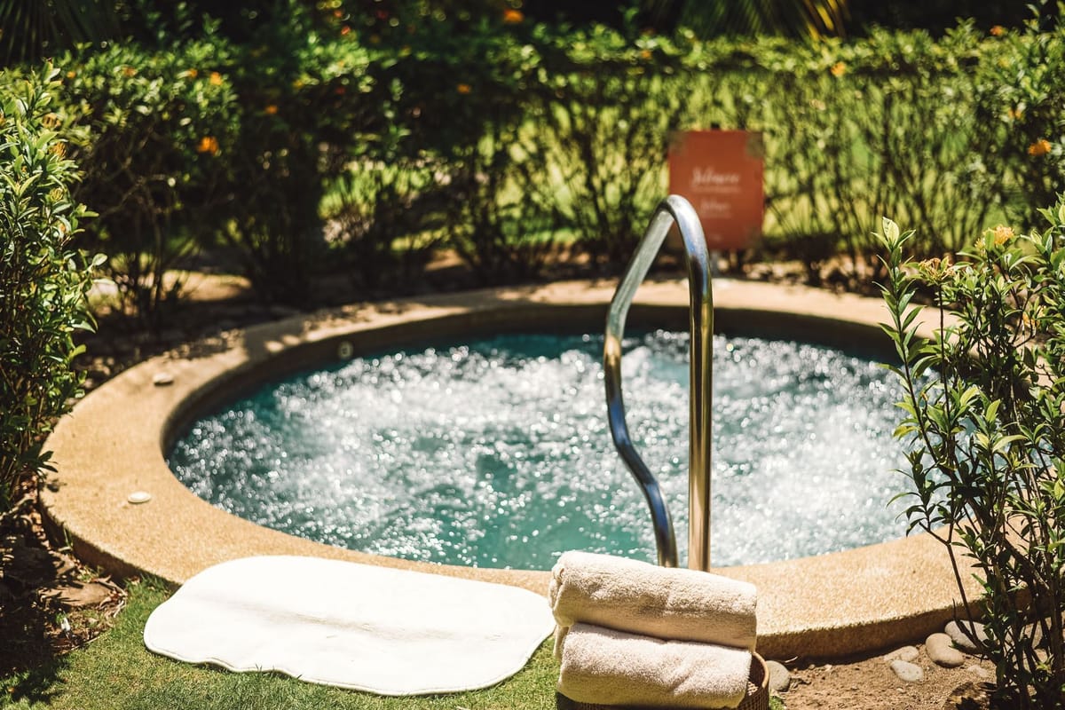 Heliconia Spa treatment bungalow interior with massage table and tropical garden views