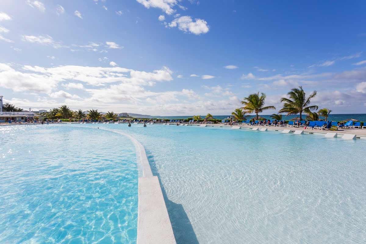 Beachfront view at Grand Palladium Jamaica Resort with Caribbean Sea, beach loungers, umbrellas, and non-motorized water sports area