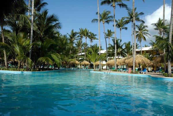 All-inclusive resort experience at Grand Palladium Palace showing the Infinite Indulgence program with dining, pools, and Caribbean lifestyle