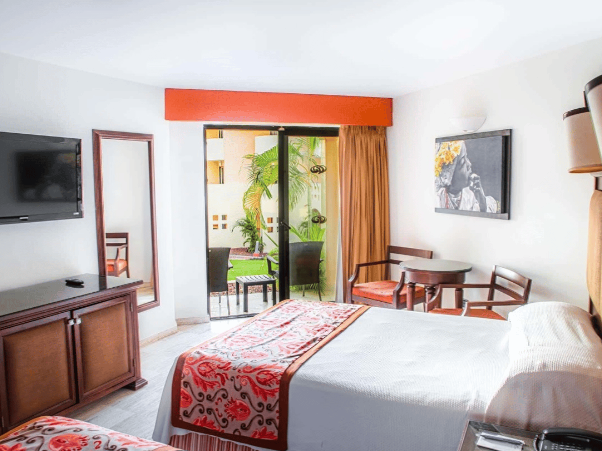 Deluxe Garden View room with king bed, dark-wood furnishings, and furnished terrace